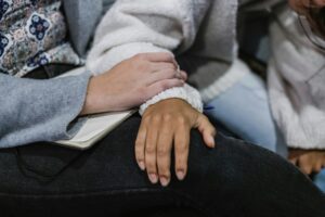 "Close-up of a person gently placing their hand over another's, offering quiet comfort and support.