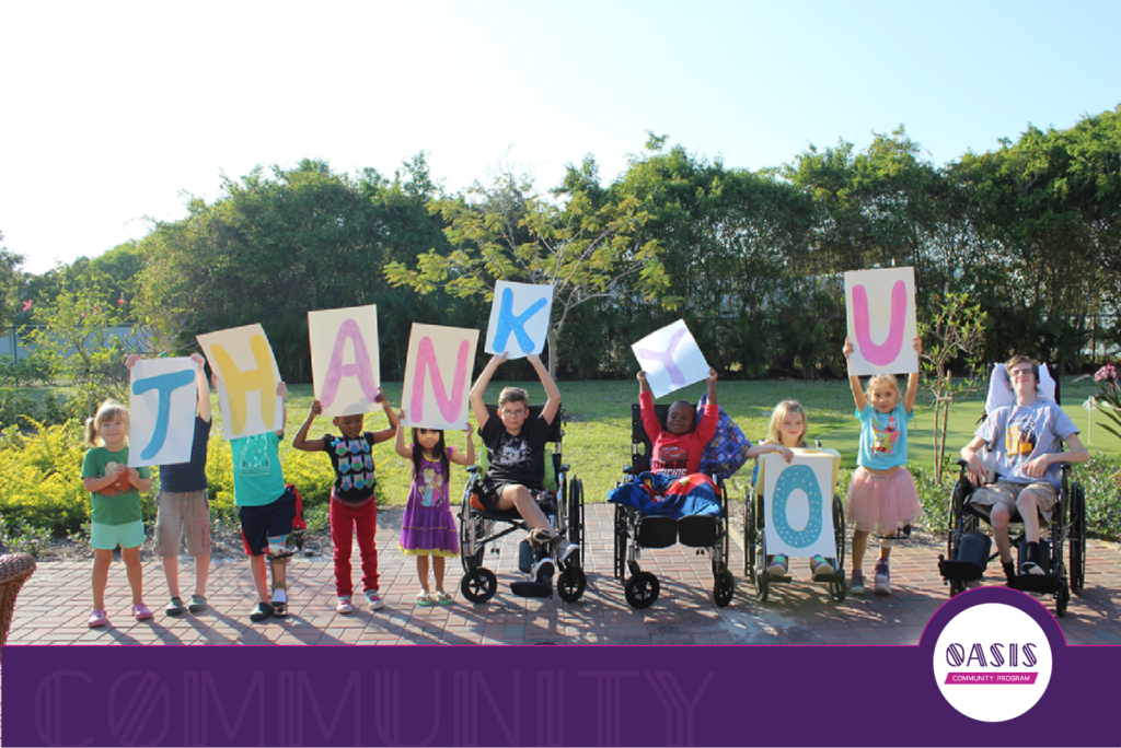 Children, including some using wheelchairs, hold colorful letters spelling “THANK YOU” outdoors, representing families supported by Quantum House during serious medical treatment in Palm Beach County.