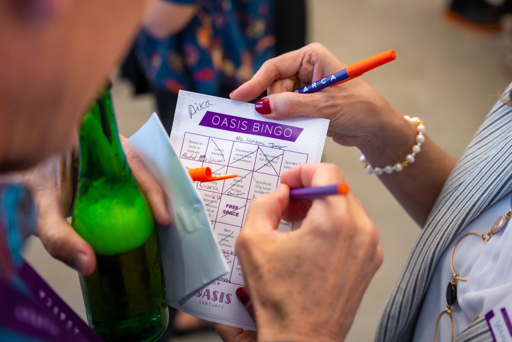Close-up of guests filling out a playful “Oasis Bingo” card at Oasis Mixer, Abarca Health’s innovation networking event in Santurce.